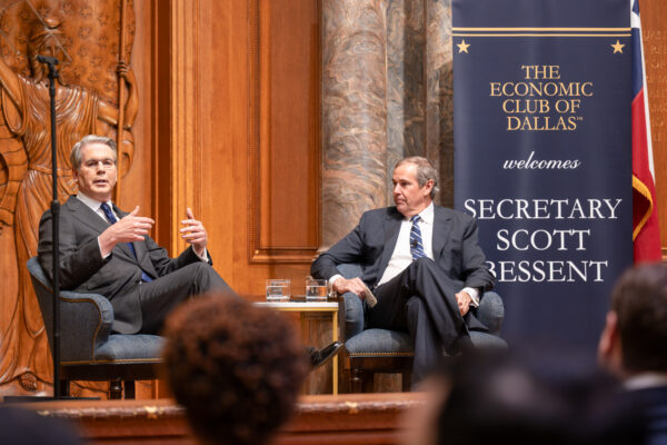 Two men seated at event, chatting
